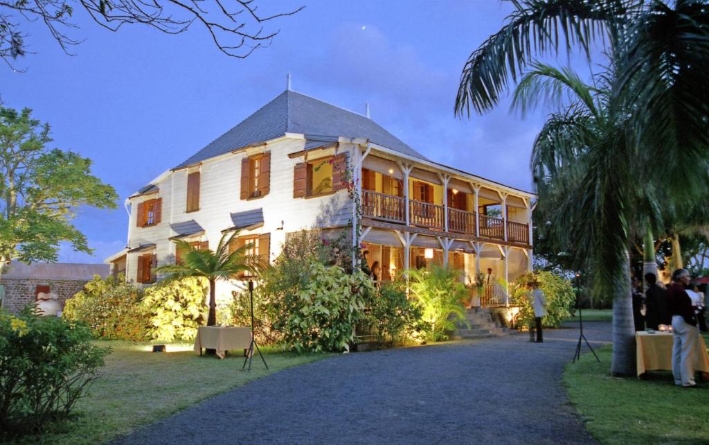 un gran edificio blanco con gente parada frente a él en Le Jardin de Beau Vallon, en Mahébourg