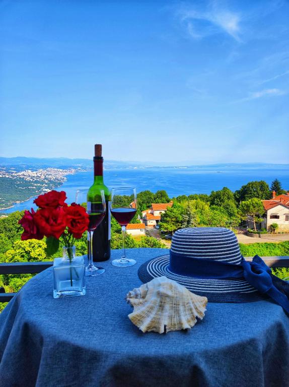 a blue table with a bottle of wine and glasses at Uphill Opatija Apartment in Opatija