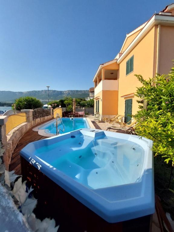 a large blue bath tub sitting next to a house at Apartments Maris in Vranjic