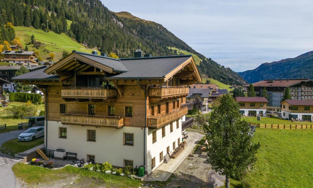 a large wooden house in a village in the mountains at Haus Arnika in Sankt Jakob in Defereggen