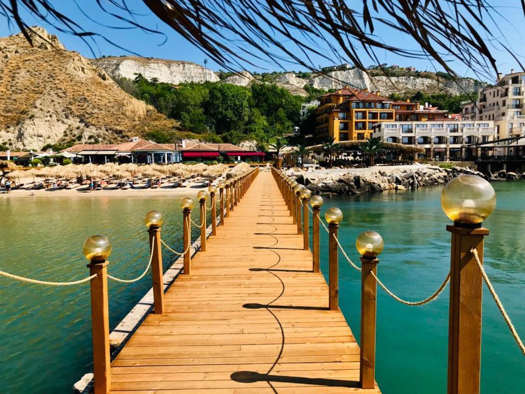 a wooden bridge over the water next to a beach at Supreme appartment in Balchik