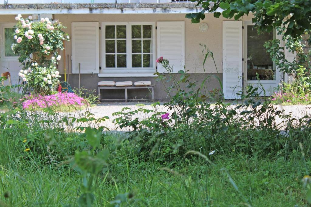 una casa con un jardín con flores delante en - les vieux fourneaux -, en Nantiat