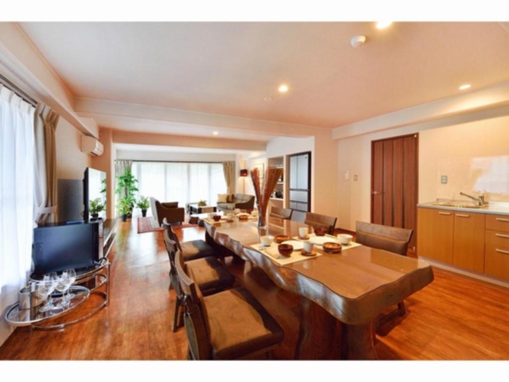 ein Wohnzimmer mit einem langen Tisch und einem Esszimmer in der Unterkunft Resort Yufuin - Grandpia Resort YUFUIN - - Vacation STAY 73417v in Yufu