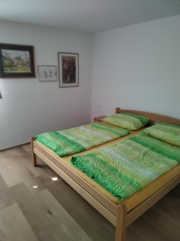2 letti in una stanza con cuscini verdi di Apartment Jalen a Bohinjska Bela