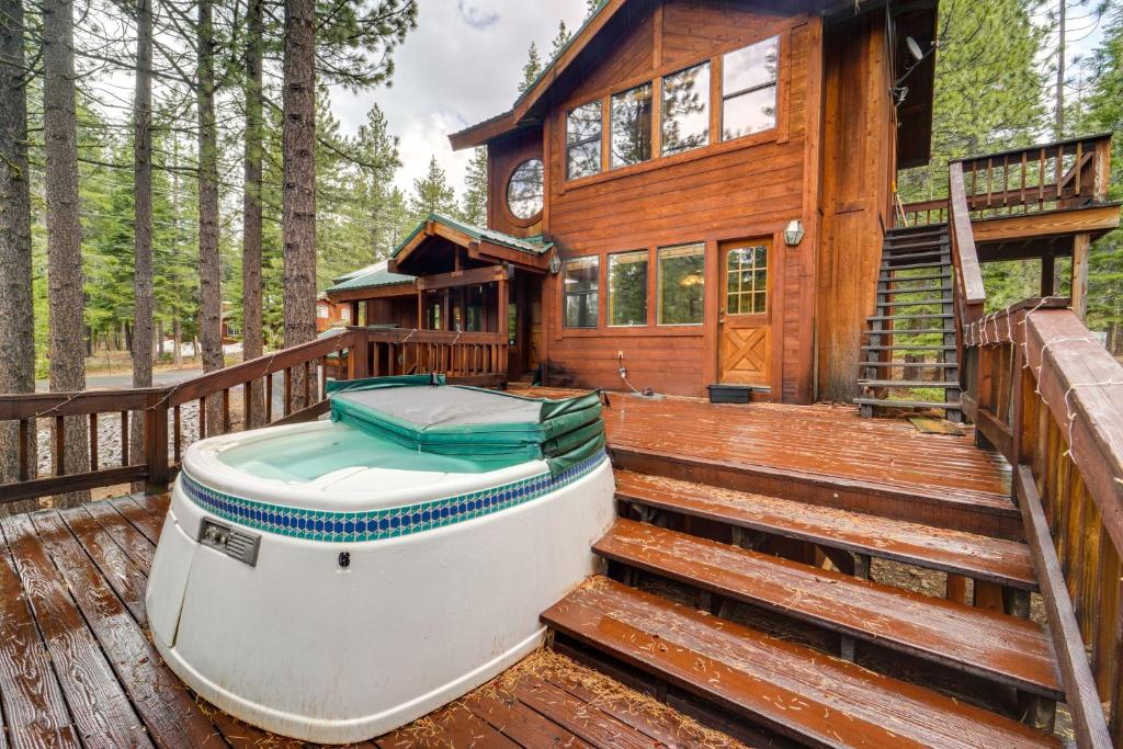 un barco sentado en una cubierta junto a una casa en Truckee Cabin Getaway with Private Hot Tub!, en Truckee