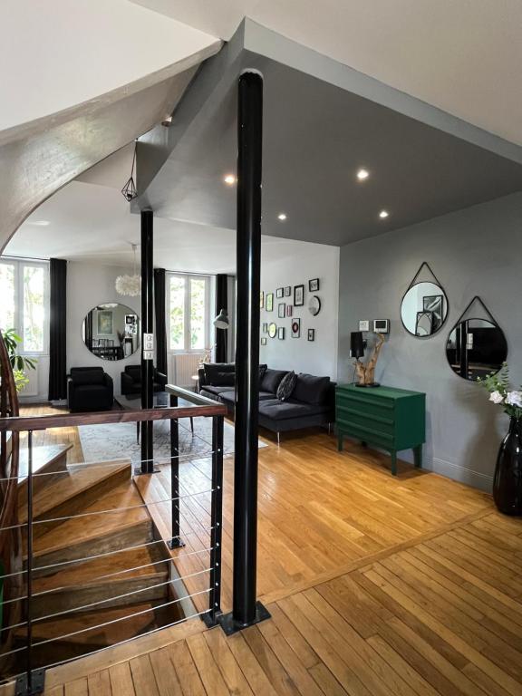 un soggiorno con una scala e un divano di Duplex de charme en centre ville avec terrasse a Brive-la-Gaillarde