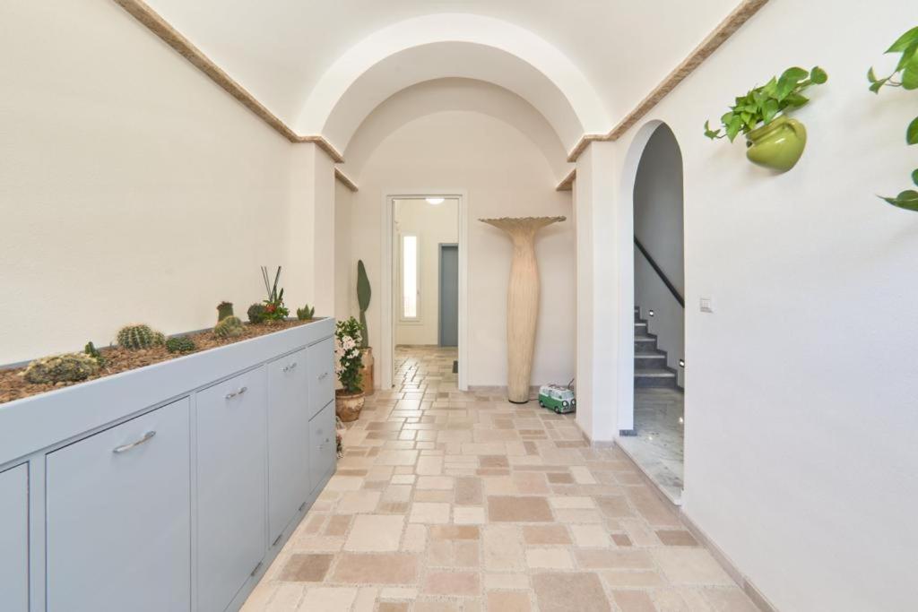 un couloir avec des armoires blanches et du carrelage dans l'établissement Casa dei Nonni, à Avetrana