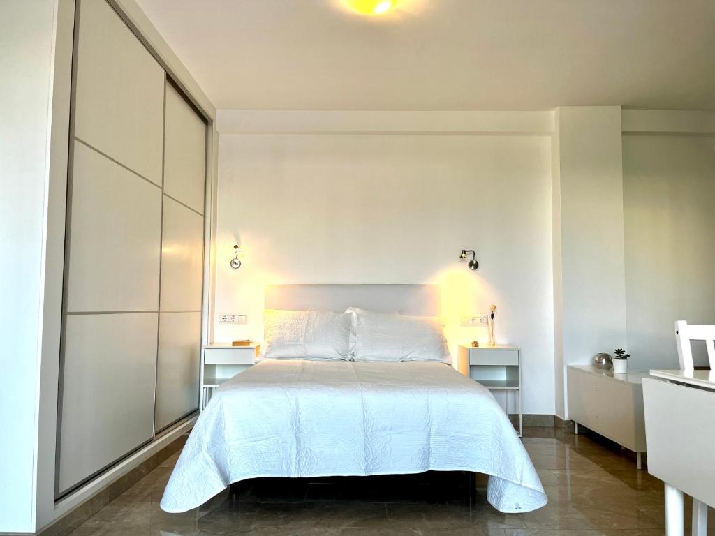 Un dormitorio con una cama blanca y dos mesitas de noche. en Panorama, en Torrox Costa