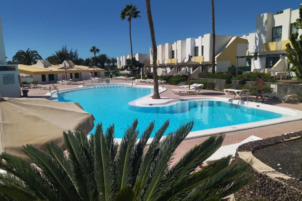 a large blue swimming pool in a resort at Bungalow Capri Maspalomas in San Bartolomé