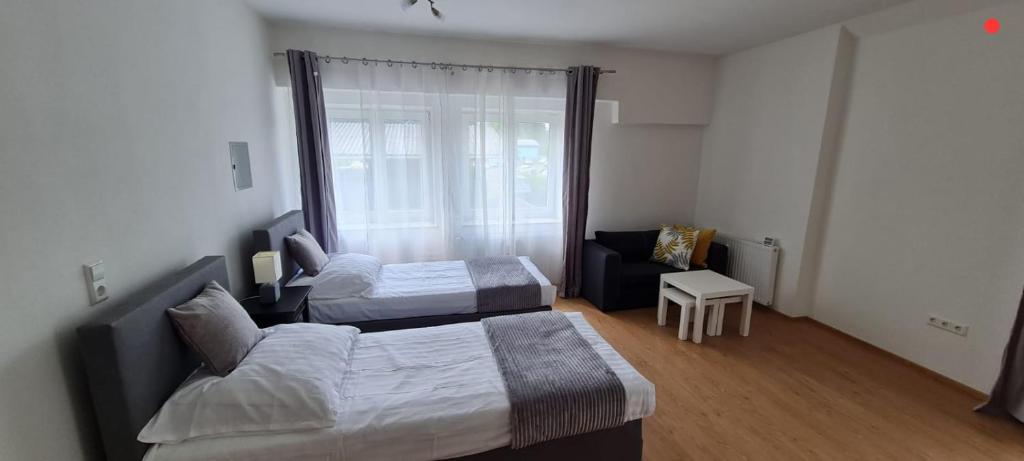 1 dormitorio con 2 camas, sofá y ventana en TOP 06, en Fohnsdorf