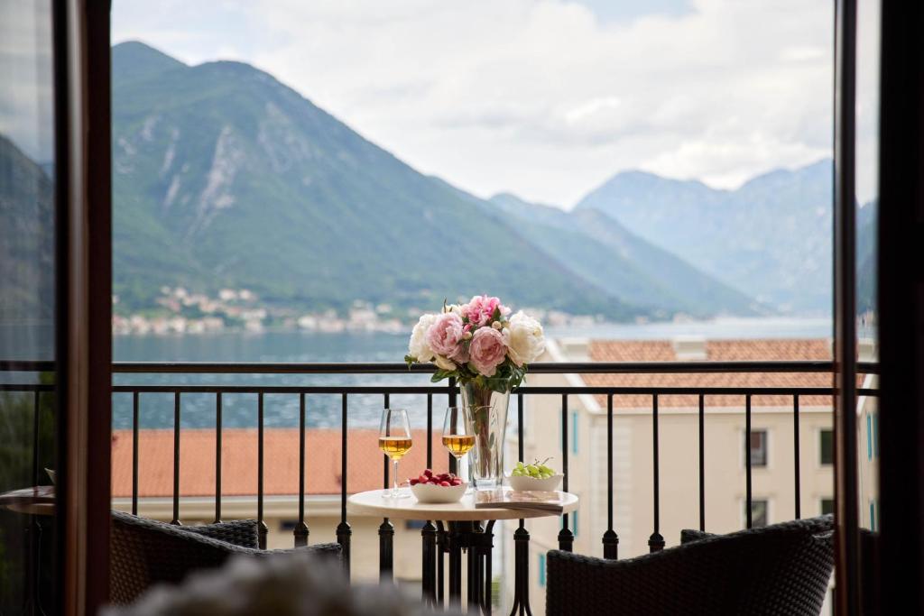 a table with a vase of flowers on a balcony at Apartments Djuranovic in Kotor