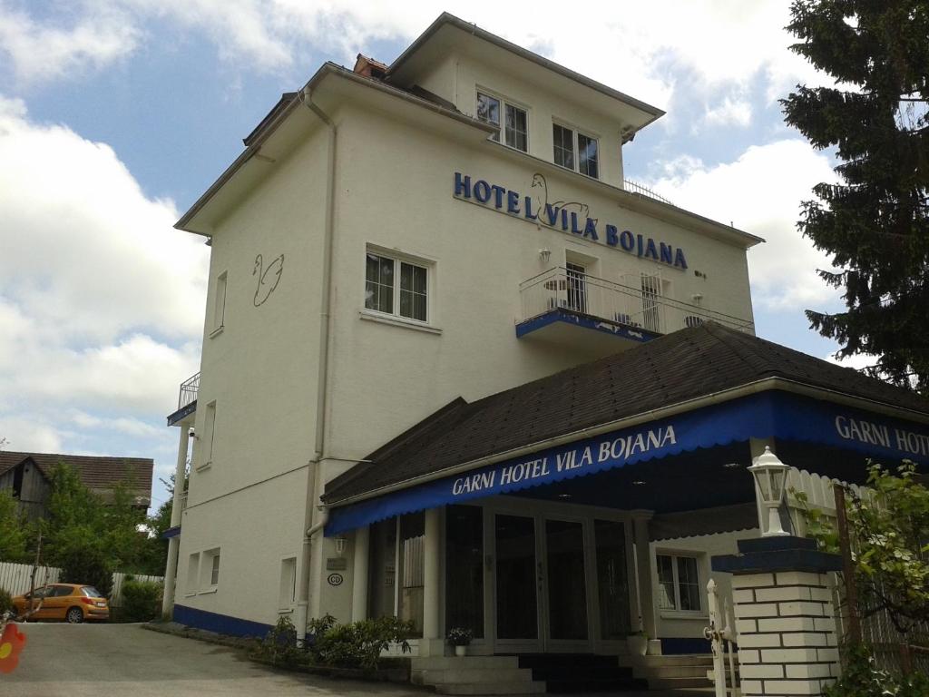 a building with a sign on the side of it at Hotel Vila Bojana in Bled