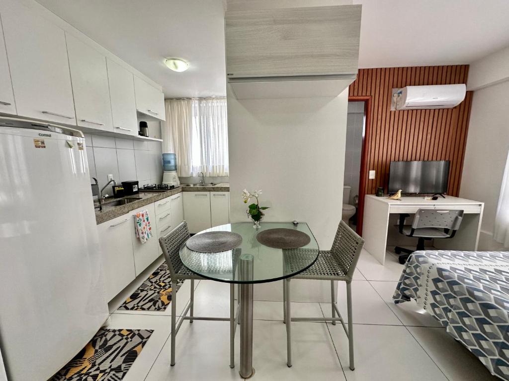 eine Küche mit einem Glastisch und Stühlen im Zimmer in der Unterkunft Golden Point in Recife