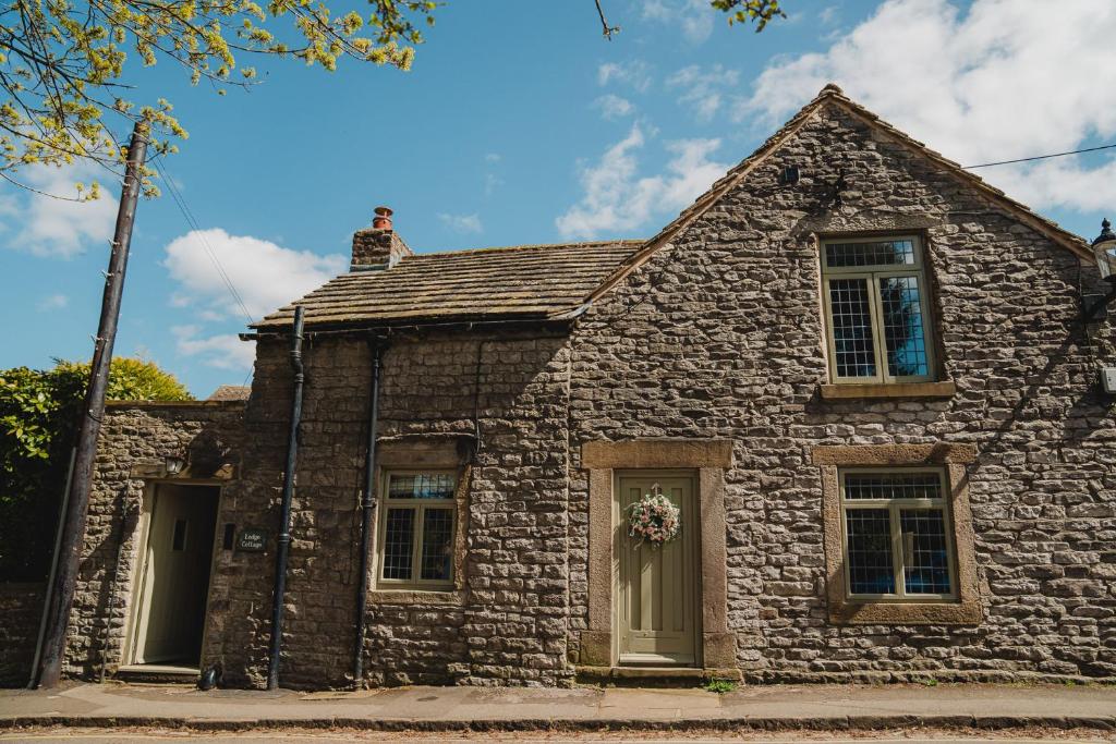 una vieja casa de piedra en una calle en Lodge Cottage, Castleton, en Castleton