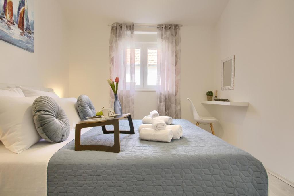 ein weißes Schlafzimmer mit einem Teddybär auf dem Bett in der Unterkunft Piccolo Giardino in Kali