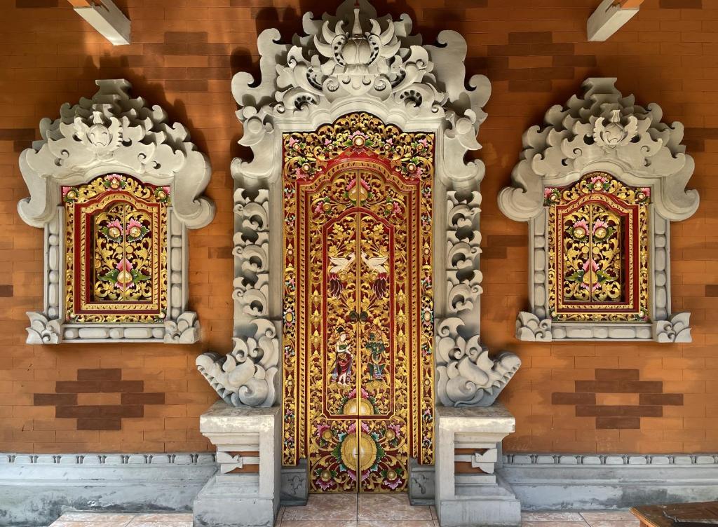 a golden door on the side of a building at Kubu Elsa Bali in Lovina