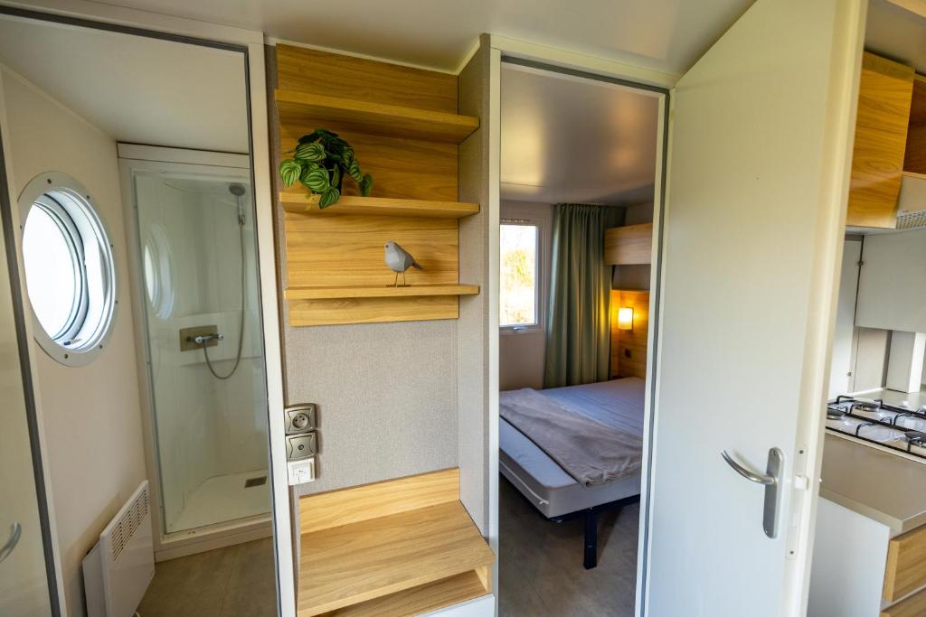 two views of a small room with a bedroom at Mini Camping Het Schuttersplek in Drogeham