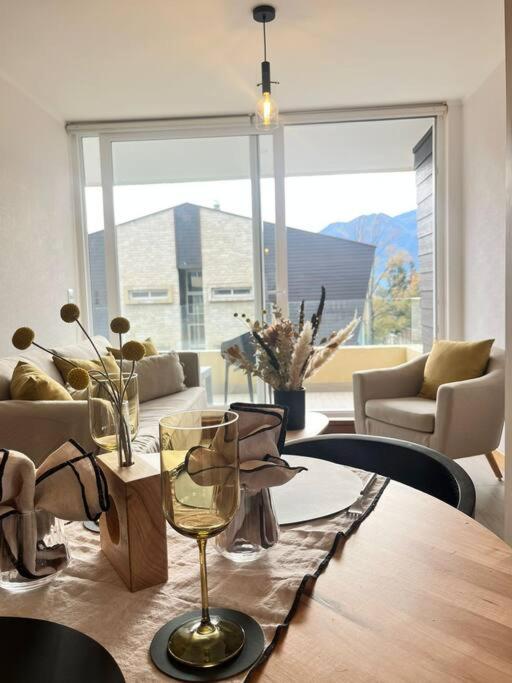 a dining room with a table and a large window at Condominio Alta Vista Pucón in Pucón