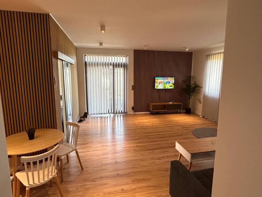 a living room with a table and chairs and a television at Luxury 2 bedroom apartment and garden 