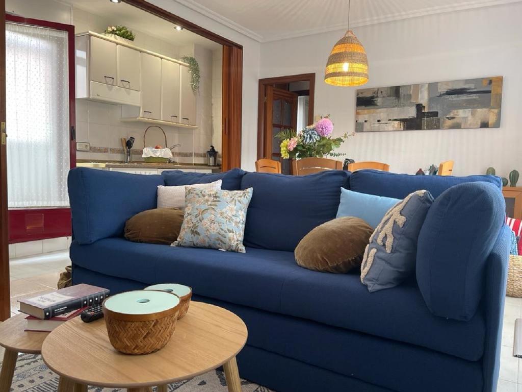 - un canapé bleu dans le salon avec une table dans l'établissement Ático Blue Charme Santo Tomás, à Salamanque