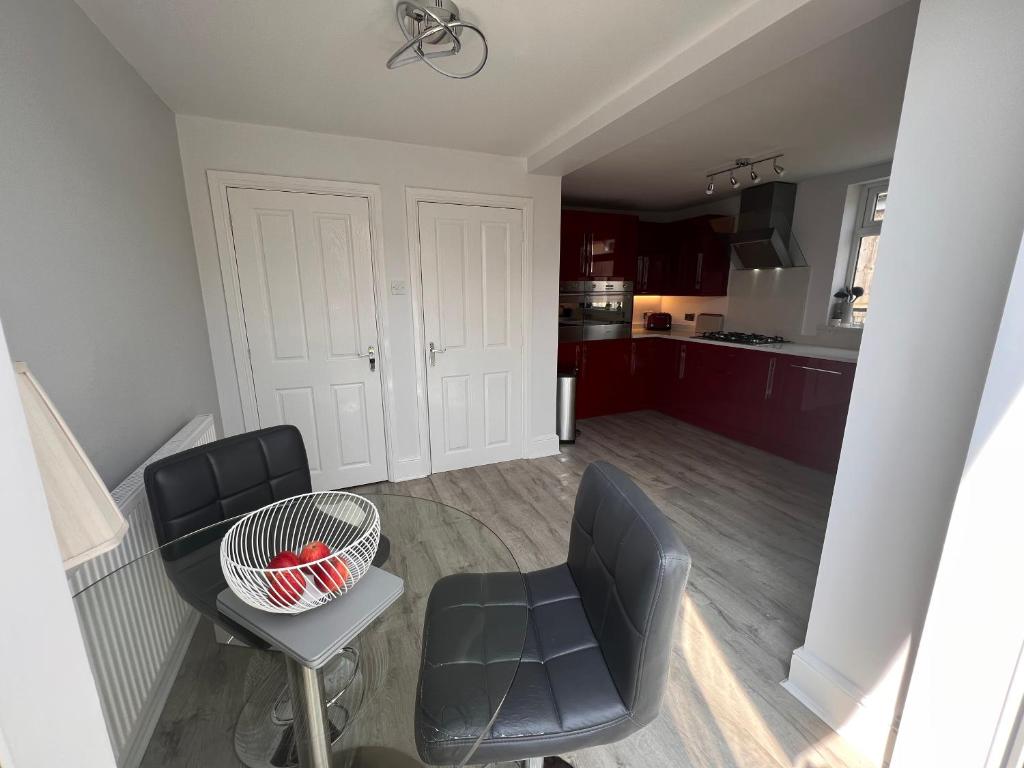 Zimmer mit 2 Stühlen, einem Tisch und einer Küche in der Unterkunft Golf Open Property to Rent Dates available 15th - 23th July in Wallasey