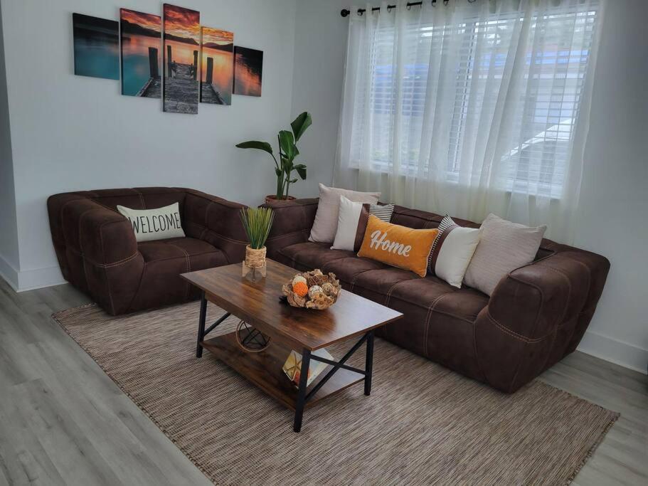 uma sala de estar com um sofá de couro castanho e uma mesa de centro em Sol Miami #1 with free parking on premises em Miami