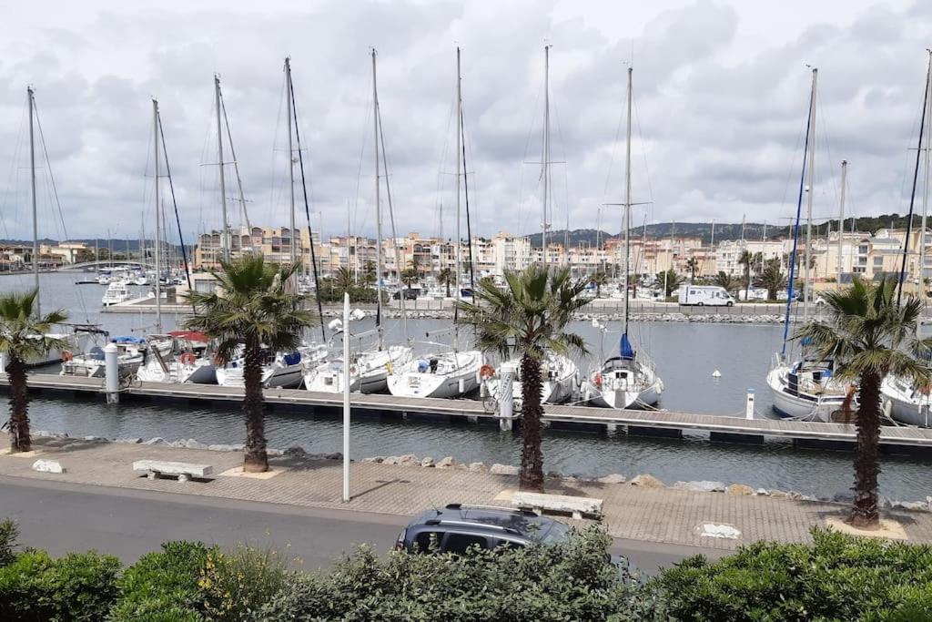 un port de plaisance avec des bateaux dans l'eau et des palmiers dans l'établissement Appart. calme 5 Pers vue sur le port de gruissan, à Gruissan