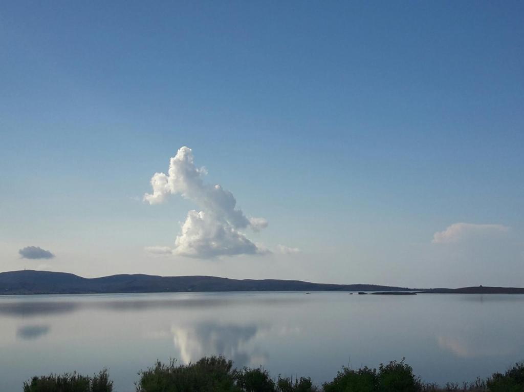 Un nuage dans le ciel au-dessus d'une grande étendue d'eau dans l'établissement Seaside resort / Lemnos, 