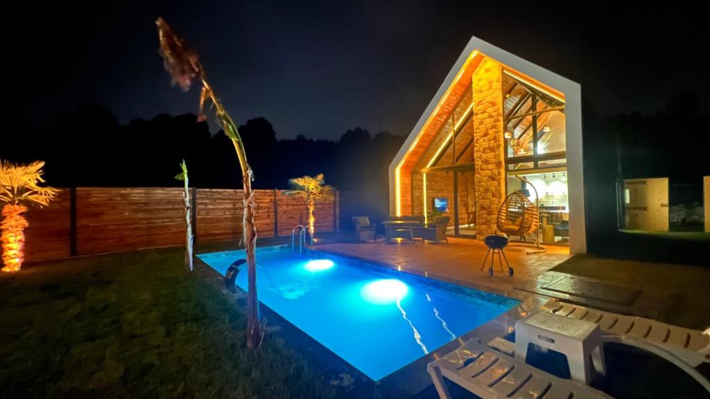 een huis met een zwembad in de nacht bij OYARC SAPANCA VILLA / BUNGALOW in Sakarya