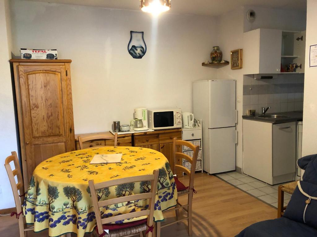 uma pequena cozinha com uma mesa e um frigorífico em Appartement Enchastrayes, 2 pièces, 5 personnes - FR-1-165A-144 em Enchastrayes