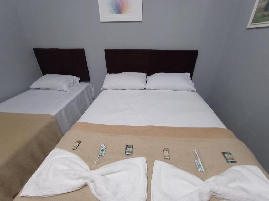 two beds in a room with ties on them at CASA DE CAMPO SENHORA SANTANA in Rio de Contas