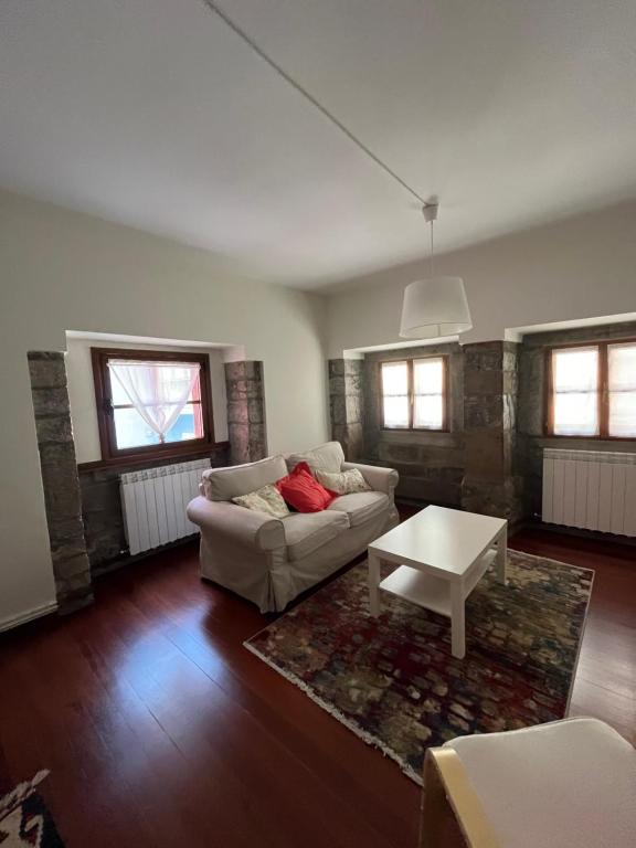 een woonkamer met een bank en een salontafel bij La Capilla in Ribadesella