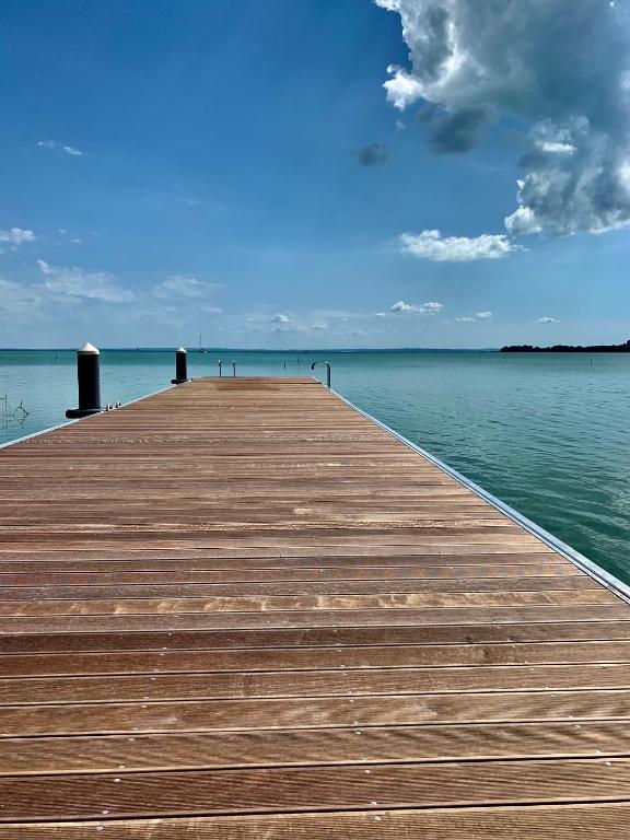 a wooden pier in the middle of the water at Fűzliget2- Green Lake in Balatonfůzfő
