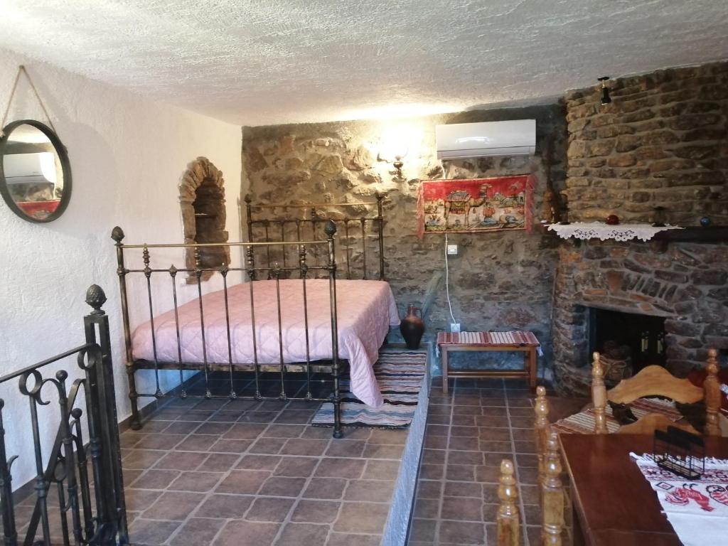 ein Schlafzimmer mit einem Bett und einer Steinmauer in der Unterkunft ΑΝΑΒΑΤΟΣ ΕΞΟΧΙΚΗ ΚΑΤΟΙΚΙΑ ΙΙ in Chios