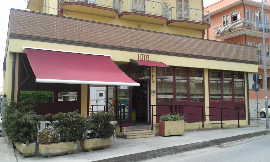 un bâtiment avec un auvent rouge dans une rue dans l'établissement Hotel Nuova Doel, à Sottomarina