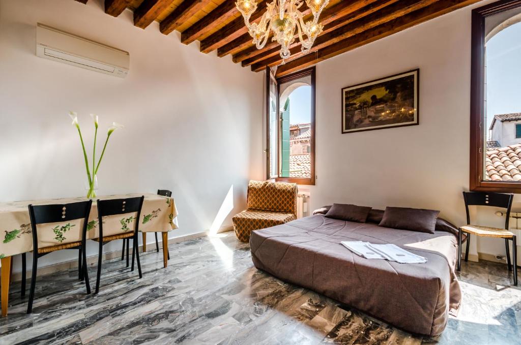 sypialnia z łóżkiem, stołem i krzesłami w obiekcie Venice Apartments w Wenecji
