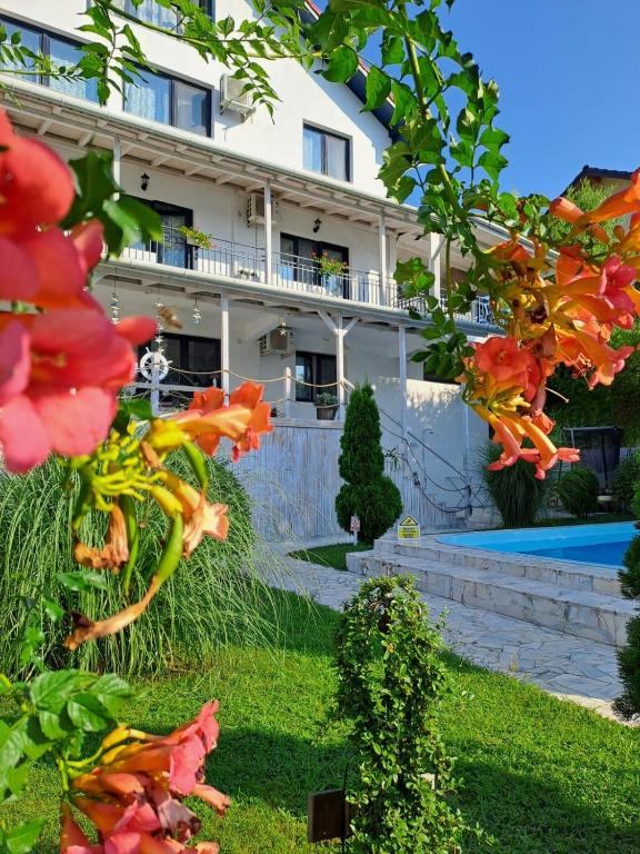 a building in the background with flowers in the foreground at Vila Selina in Eşelniţa