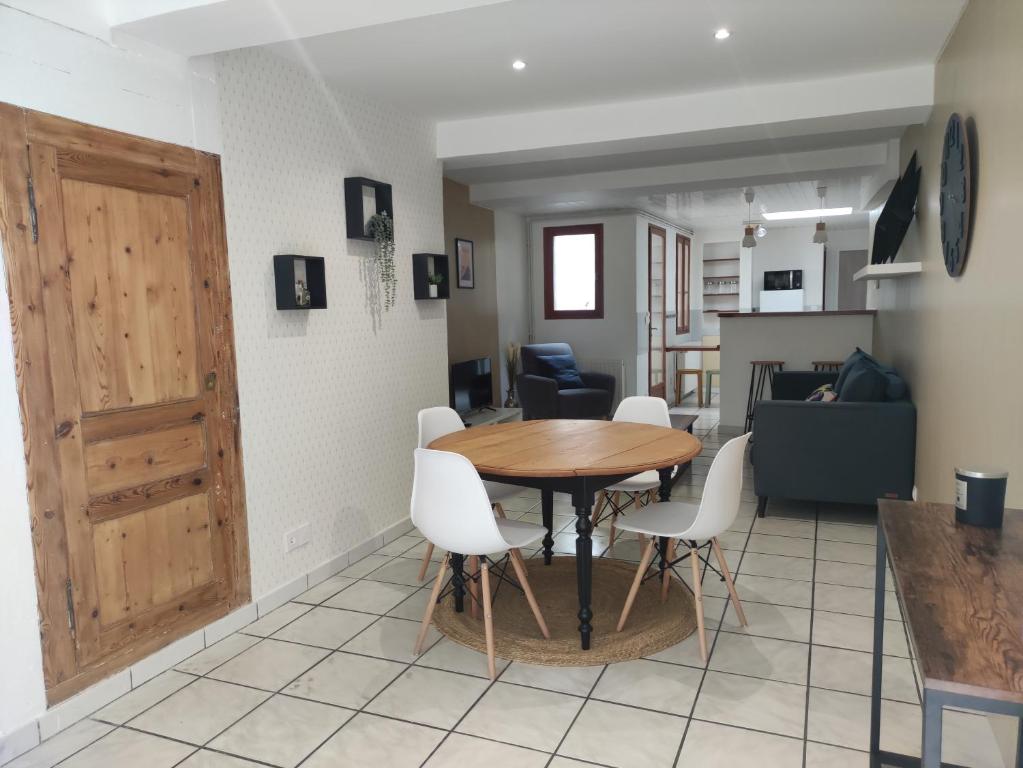a dining room and living room with a table and chairs at Maison cosy au cœur de la vieille ville in Boulogne-sur-Mer