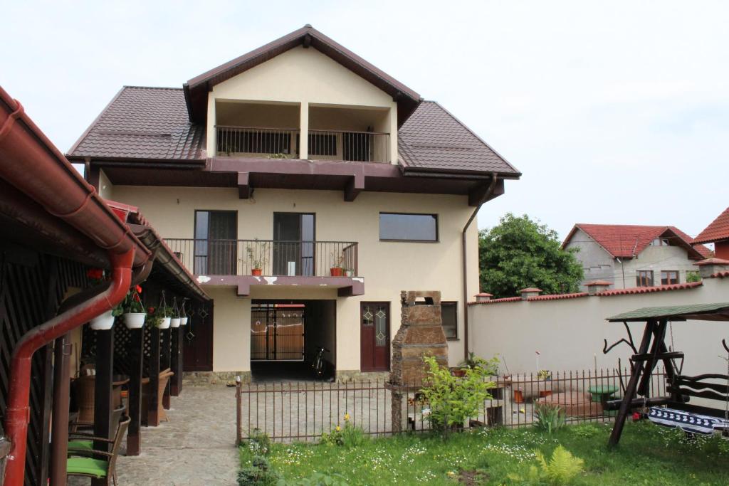 a house with a fence in front of it at Pensiunea Giovani in Târgu Jiu