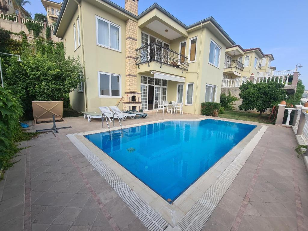 a swimming pool in front of a house at Alanya gold city villa in Alanya