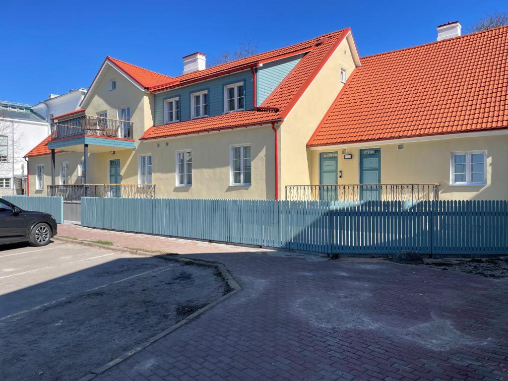 ein Haus mit einem orangenen Dach und einem Zaun in der Unterkunft Bürgermeistri majutus in Haapsalu