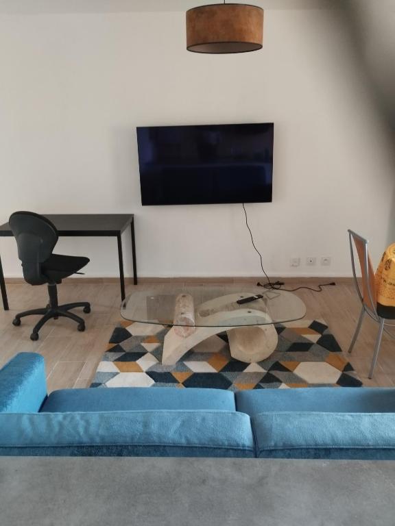 sala de estar con sofá azul y mesa en appartement 4 couchages renovés entièrement, en Cavaillon