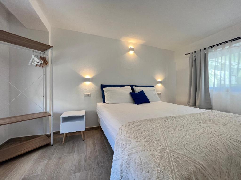 Un dormitorio con una cama grande y una ventana en Via Giardini Rooms en Villasimius