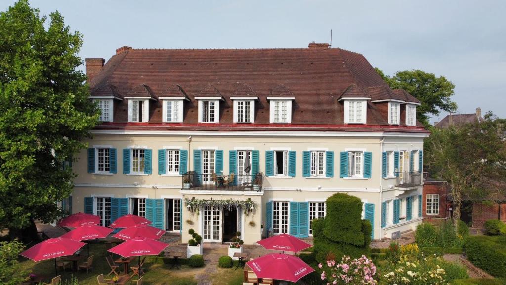 una grande casa con ombrelli rossi davanti di Chateau De Montreuil a Montreuil-sur-Mer