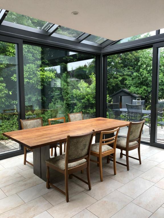 Ferienhaus mit eigenem Garten und Terrasse في Lindau-Bodolz: غرفة طعام مع طاولة وكراسي خشبية