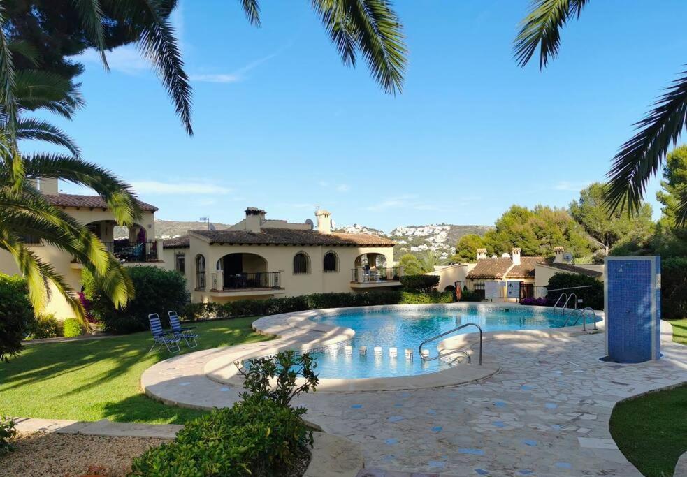 ein Haus mit einem Swimmingpool im Hof in der Unterkunft Apartamento en moraira con piscina in Moraira