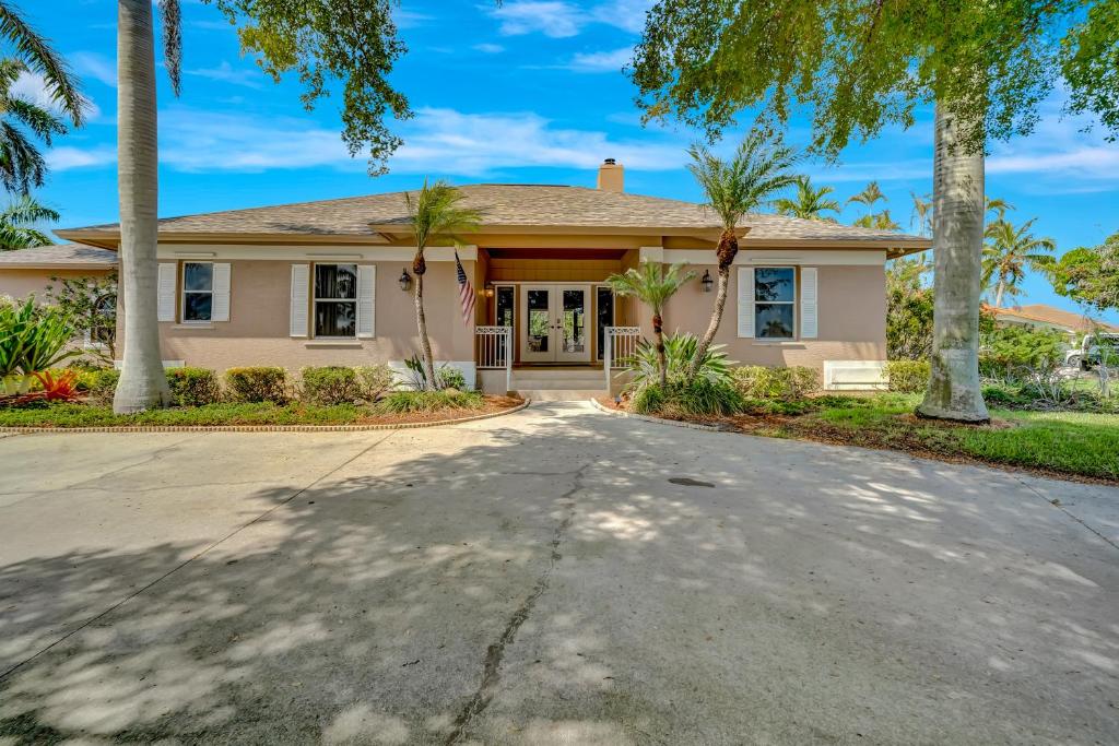 a house with palm trees in front of a driveway at Tranquil Haven in Marco Island