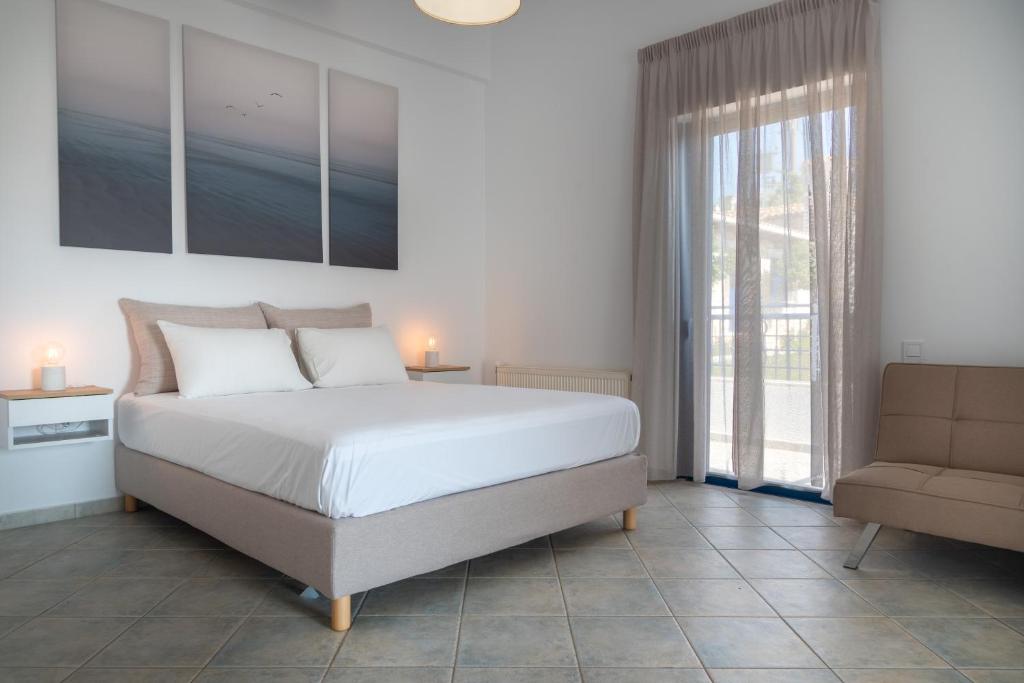 a bedroom with a bed and a couch and a window at Villa Rodanthi Sivota in Syvota