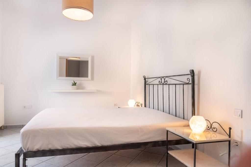 a white bedroom with a bed and a table at Villa Rodanthi Sivota in Syvota