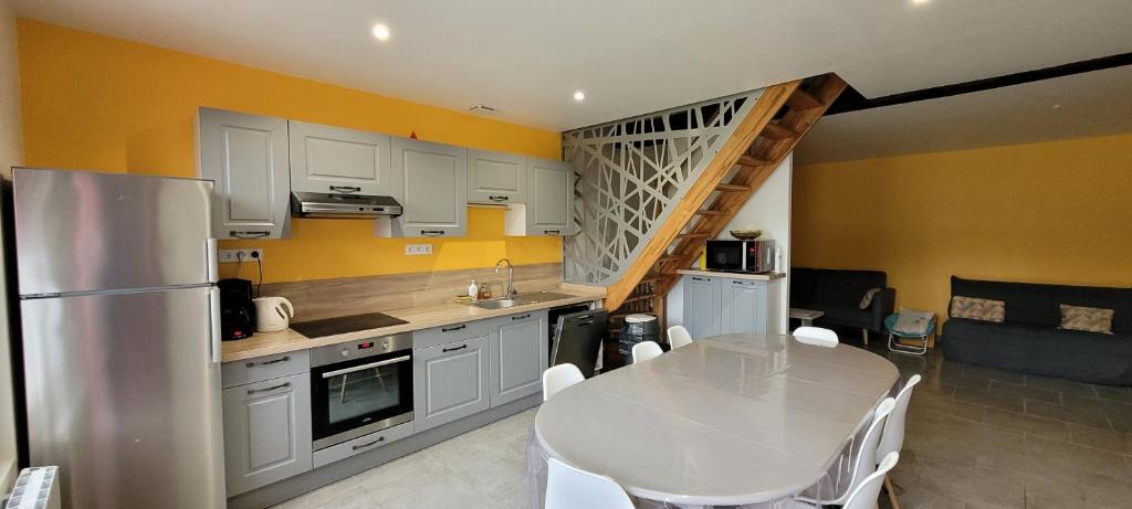 a kitchen with a table and a kitchen with yellow walls at La Graine de Beurre proche zoo de Beauval in Seigy